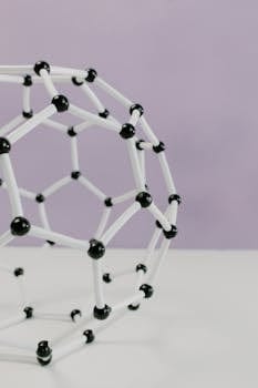 Close-up of a geometric molecular structure model against a pastel background.